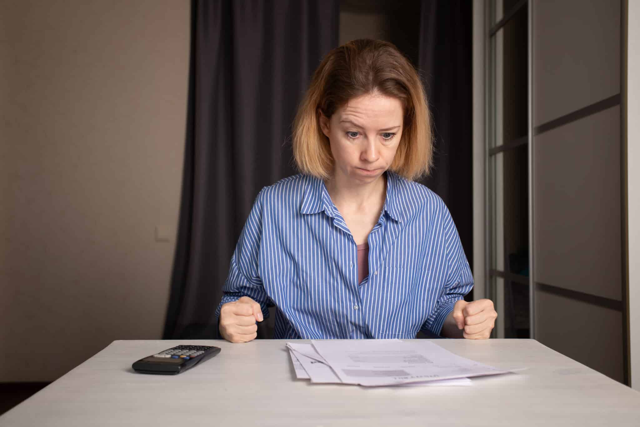Woman reviewing water bill, Heat-Induced Pipe Cracking.