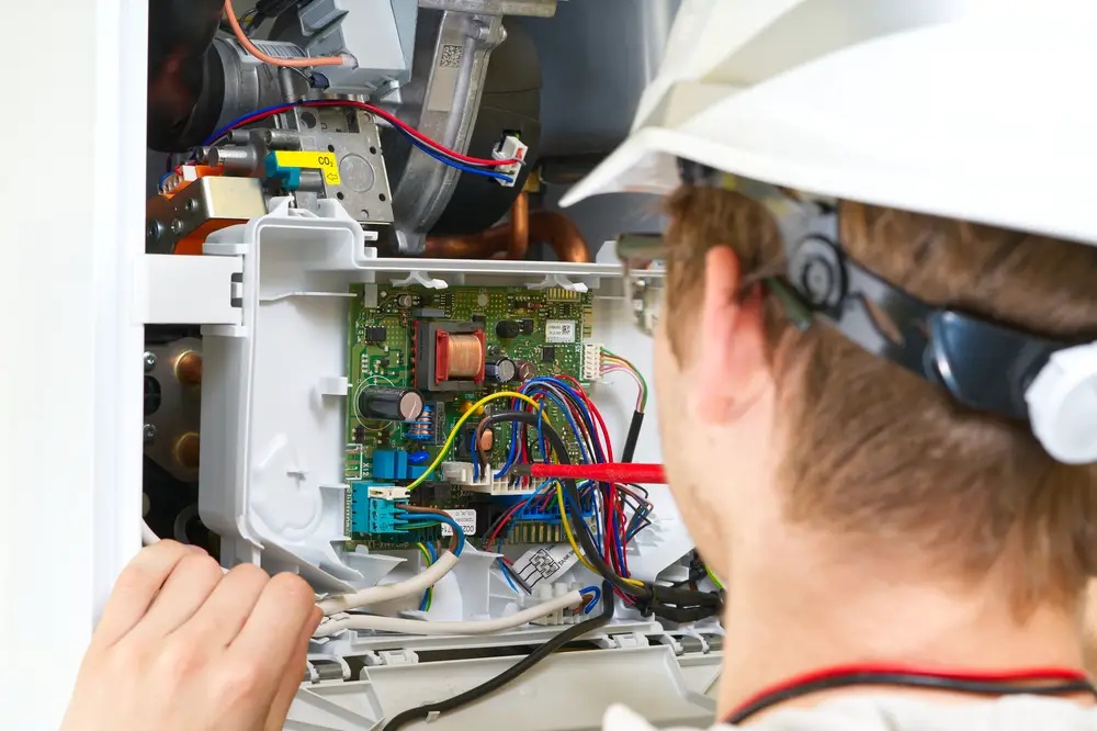 technician repairing a gas water heater